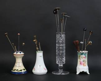 242	23 Vintage Hatpins With Holders	23 vintage hat pins with holders. Hatpins including rope, trembler, silver tone, gold tone, organizational, rhinestone. In four porcelain and glass holders, including cut glass, RS Prussia, Heinrich, Torquay pottery. Trembler 6 1/2"L, glass hatpin holder 8 1/4"H. Fleabites to rim of glass holder.
