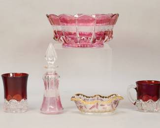 40	7 Pieces Glass Including Ruby, Cranberry	7 piece glass lot. Ruby to clear creamer, pair of cups, Cincinnati souvenir beaker; cranberry to clear perfume, nut dish with cranberry flower and leaf decoration, cranberry to clear bowl. Perfume 7 5/8"H, bowl 3 3/4"H x 8 1/2"-diameter. Ruby cut to clear all with chips and fleabites, beaker with scratches, perfume chips to interior end of stopper and significant losses to color; losses to color on bowl and scratches to interior.
