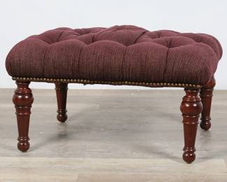 218	Stickley Upholstered Footstool	"Stickley upholstered footstool. High Point, NC. Turned legs and maroon tufted upholstery. Stickley metal tag on underside of footstool. Light wear and pilling throughout upholstery. Light scuffs and nicks to wood on legs.

26 1/4"" W x 20"" D x 16"" H. 12 lbs."
