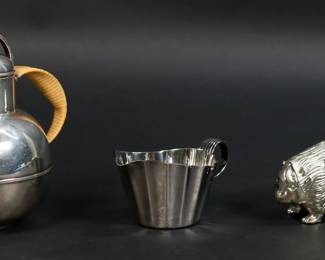 259	3 Pieces Modern Silverplate Vignelli, Bernard Rice	3 pieces modernist silverplate. Bernard Rice's Sons Apollo teapot with rattan handle, 5 5/8"H; (Massimo) Vignelli Designs Italy creamer, 2 1/8"H; figural porcupine toothpick holder, 4 7/8"L. Apollo teapot dent to one side, teapot and creamer both with light scratches.
