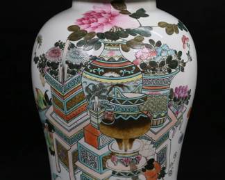 184	Chinese Porcelain Ginger Jar	Chinese porcelain lidded ginger jar. Decoration of vases and flowers. Red mark to the underside, inscription and red seal to one side. 16 1/2"H. Scratches to lid, chip to finial, chip to inner rim of lid, imperfections to glaze along base of jar.
