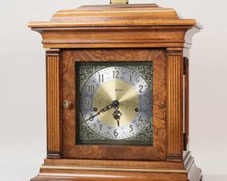 433	Howard Miller Mantel Clock	Howard Miller mantel clock, 1050-20. Wooden case, gold and silver tone dial, 2 jewels. Runs, timekeeping untested. 14 1/4"W x 8"D x 16"H not including handle.

