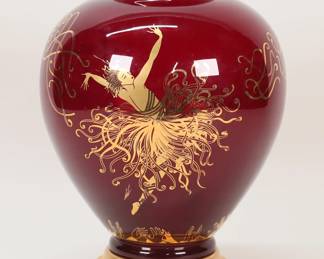 435	After Erte Franklin Mint Applause Vase	After Erte (Romain de Tirtoff) (Russian / French, 1892-1990). Franklin Mint ruby glass vase, with gilt art deco decoration, after Erte's Applause. On a gilt metal base. Vase 9"H (with base 10 1/4"H). Chip to rim.
