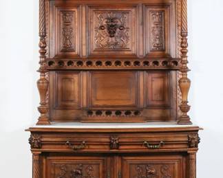 209	French Renaissance Revival Buffet Deux Corps	"French Renaissance Revival tiered buffet or buffet deux corps. Early 20th century. White marble top, carved demon grotesques, two drawers and two doors. Key is included. Marble is broken in two pieces. Scratches and scuffs to marble. Warping and bowing throughout construction of buffet. Crack to wood on bottom tier underneath cupboard space. Molding around inset marble is loose. Molding on bottom is loose with right side separating. Later lock mechanism to door. Lock works but doors do not shut closed. Loss to wood on left turned support. Crown of buffet is slightly warped. Repairs to molding on left bottom corner of carved back. Losses to molding around repaired section. Later brackets and hardware on back of buffet. 
49 1/4"" W x 19 1/2""  D x 102"" H."
