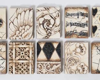 430	14 Sid Dickens Memory Blocks	14 Sid Dickens Memory Block wood and plaster tiles / wall plaques. Designs including music, piano keys, foliate motifs. Each 8" x 6" x 1 1/4"D. Most with losses to black paint on the reverse, two  with chips to corners.
