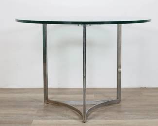 157	Baughman Style Mid Century Modern Center Table	"Mid Century Modern center table in the style of Milo Baughman (Goodland, KS, 1923-2003). Curving triangular-form chrome base with 3/4"" thick glass top. Heavy tarnishing, rusting and wear throughout chrome. Heavy scratches and wear throughout glass. Small fleabites and scuffs to edges of glass. 

28 7/8"" H x 41 3/4"" diameter. 106 lbs."
