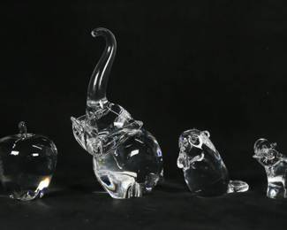 138	6 Pieces Steuben Crystal Figures & Paperweights	6 pieces signed Steuben, including animal figurines, paperweights. Flag, 2 1/4"H; eagle, 3 1/4"H; apple, 4 1/8"H; beaver, 3 1/2"H; two elephants, larger 9"H. Chips to base of eagle, minor chips to base of smaller elephant.
