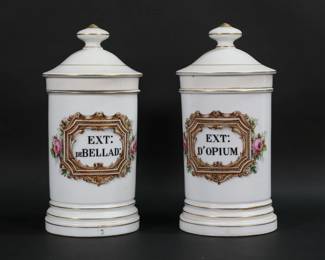 30	Pair of French Porcelain Apothecary Jars	Pair of French porcelain apothecary / pharmacy jars. Hand painted with flowers and framed lettering, labeled for opium and belladonna. Each 10 5/8"H including lids. Firing cracks to the base of belladonna jar, paint loss to finials and minor paint loss to gilt decoration.
