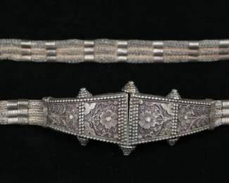 373	Thai Silver Belt	Silver belt, floral buckle and woven silver thread, screw closure. Thailand, unmarked, acid tested as silver. 28 1/2"L, 438 grams. Band closest to buckle on one end cracked.
