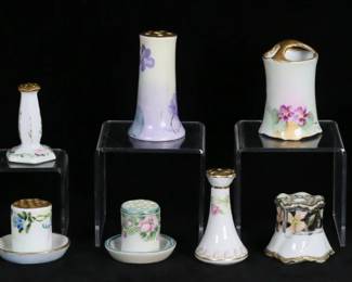 246	Lot of Stick Pin Holders	"Lot of 14 stick pin holders. 12 porcelain, including Limoges, Nippon, hand painted, Austrian; gilt metal car pin cushion, marked U.S.A on the underside; ebony wood screw top pin case with silver overlay lettering with illegible maker's mark.  Car 3""L, Austrian porcelain 2 5/8""H. 

Largest porcelain holder with chips and repairs to lower rim, most with minor losses to gilt painted decoration, Austrian porcelain flakes at top; ebony minor chips along bottom edge."
