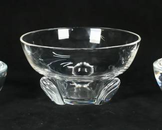 142	3 Steuben Crystal Bowls	3 signed Steuben art glass bowls. Pair of bowls, 2 1/4"H x 5 3/8"-diameter and 2 1/4"H x 5 5/8"-diameter; Heritage series bowl marked SHS 1981 on the underside, 3 3/4"H x 7"-diameter. Pair of bowls both with chips and fleabites to the rims, scratches to the undersides and throughout; flake to one foot of Heritage bowl, fleabites and roughness to one foot.
