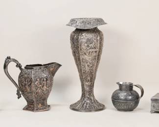 258	5 Pieces Repousse Decorated Silverplate	5 pieces repousse and relief decorated silverplate. 3 pieces Barbour International Silver Co.: vase with interior scenes, 13"H; pitcher with dancers and musicians, 8"H to top of handle; jug with village scenes, 4"H; With an unmarked box with interior scene on lid and dancers, 4 3/8"W x 2 1/8"H; and a Webster crystal bottle with silverplate fittings with genre scenes, 5 7/8"H. Rim of vase bent on one side.
