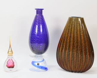 129	3 Pieces Art Glass R Roland, Carlo Moretti, Murano	3 pieces art glass. Roger Roland perfume, signed and dated 96 on the underside, 7 1/8"H including stopper; Carlo Moretti Murano glass decanter, no stopper, cobalt with gilt flecks, signed and with partial paper label, 12 1/4"H; Barovier style Murano vase, ribbed cobalt interior with amber and gilt decoration, unsigned, 10 3/4"H.
