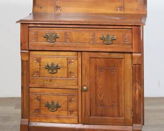 52	Victorian Washstand	"Victorian washstand. 19th century. Backsplash, one door, three drawers with pin and cove dovetailing. Wear throughout wood. Marks, staining and scratches to wood of top. Tarnishing and wear to brass of drawer pulls. Split and crack to wood on right side of washstand.

30"" W x 17"" D x 37"" H. 50 lbs."

