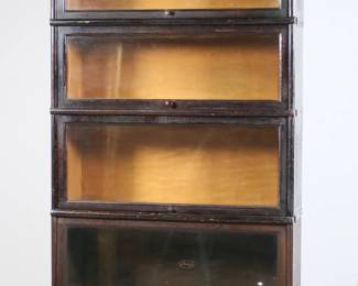 105	Macey Four-Stack Sectional Barrister Bookcase	"Four-stack barrister style sectional bookcase by Macey. Early 20th century. Quartersawn oak comprised of stack crown, base, and four bookcase pieces with sliding glass doors. Macey brand mark with manufacturer information on support of base. Macey brand mark on interior of bottom case on back panel. Mismatched knob on one bookcase. Heavy scratches, marks and wear throughout wood on crown. Small nicks and chips to wood throughout edges. Separations to metal straps on top bookcase. Wear to wood throughout all pieces. Holes and warping to back panel on bottom bookcase. Scratches and wear to all interiors. Knob on top bookcase is misaligned and bent.

34"" W x 12 1/2"" D x 61 5/8"" H. 102 lbs."
