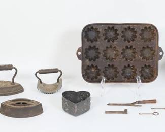 78	Lot of Early Cast Iron & Tin	Lot of primitive metal items, including sad irons, cast iron Eagle toy stove, cast iron Turk's head pan, punched tin heart mold, tools, cast iron Geneva hand fluter, hanging lantern. Pan 14 1/4" x 9 5/8", lantern 14"H x 10 1/4"W x 10 1/4"D. Stove missing one burner, side and top pieces, tea kettle missing lid; curler missing one handle; one iron no handle; lantern glass on door missing at top; all with some rusting and wear.
