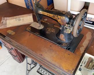 Sphinx design on hip, and ornate gold scroll work design on black sewing machine. Early 1900s
