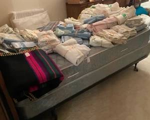 Twin beds, bedding galore, blankets galore, towels galore. 