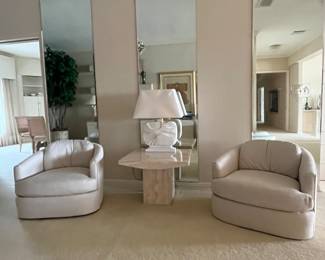 A pair of Custom upholstered swivel chairs. The fabric matches the couches and armchairs with Ottomans. In 1970s Italian  Travertine side table.
