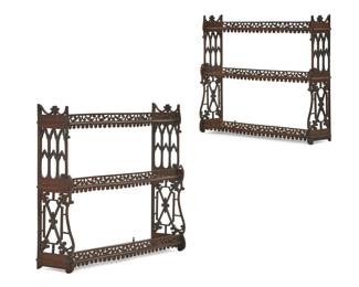 A pair of George III style fret carved mahogany hanging shelves
early 20th century