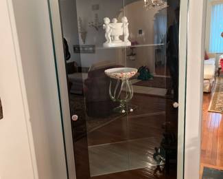 Living Room: This contemporary black display cabinet has a glass surround on its sides and top (see next photo). There are four interior shelves (two are glass) and two long glass doors. It measures 31" wide x 17" deep x 71" tall. The displayed cherub dish and art glass jellyfish bowl (Poland) are also for sale.