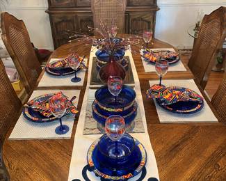 Dining Room: The dining table is now shown with cobalt blue glass plates and bowls, stemware, and matching cloth napkins all in the African KENTE pattern. A closer photo of the one of the place settings follows. All of the items shown have been put back in their original boxes and are displayed in the lower level.