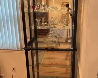 Dining Room: This lighted contemporary black display cabinet has a mirror back, glass sides, six shelves (four are adjustable, and four glass doors (two upper; two lower). It measures 32" wide x 13" deep x 76" tall. The crystal figures and MURANO art glass displayed are also for sale.