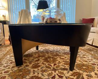 Living Room:  A unique black asymmetrical cocktail table has a round glass top and measures 44" in diameter.   It coordinates with the smaller side table previously shown.