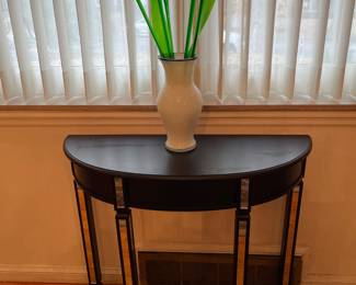 Dining Room: A black Demi-lune table has mirrored legs. The glass floral display is also for sale.