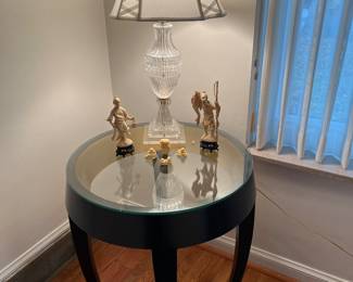 Living Room: The 24" round side table with glass top coordinates with a nearby black, asymmetrical cocktail table. The crystal lamp with Lucite base matches a nearby lamp but they have different shades. (The lamps are separately priced.) The resin (not ivory or bone) Asian figures are also for sale.