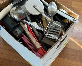 A large bankers box packed with kitchen gadgets and utensils
