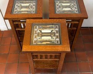 Three Mission Style Tables with Stained Glass Tops each measuring 24.5 x 15 x 15 inches.

There is some wear including one of them having some scratch marks on the legs. 