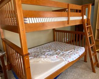 Full over full wood bunk bed with foam mattresses.