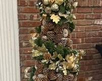 Artificial Christmas Tree Decorated In Ribbons And Pinecones
