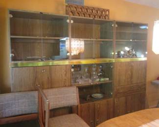 MCM-Style 3-Section Wall Unit, 2-Drop-Down Serving Bars, Attached Wine Bottle Storage & Glass-Front Display Areas.  Wood with Brass Detail Strip.                36" X 78" High (Each Unit) 