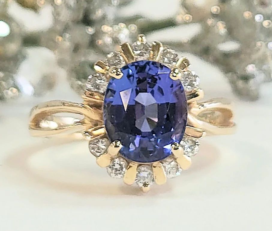 Fine oval Tanzanite aprox 2.5 ct. with diamond halo set in 14k yellow gold size 8