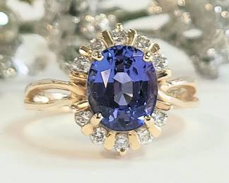 Fine oval Tanzanite aprox 2.5 ct. with diamond halo set in 14k yellow gold size 8