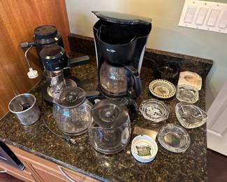 Coffee maker, vintage ashtrays, and other kitchenware.