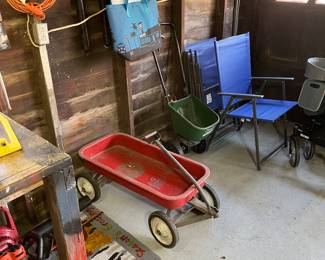 Table top Weber charcoal grill, red wagon, seed spreader, extension cords and folding chairs.