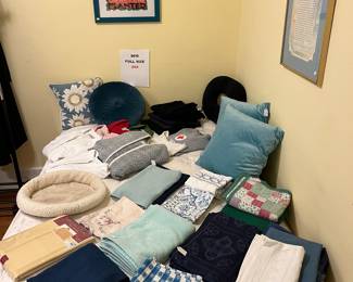 Large variety of linens displayed on a queen bed.