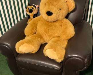 Giant teddy in a leather chair (chair is adult sized)