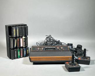 ATARI CONSOLE & GAMES | Console, joystick controllers, and a case with game cartridges. 
