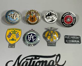 (9PC) VINTAGE METAL & ENAMEL CAR BADGES | Including; Eastern New York M.G.A. Club, British Racing & Sports Car Club, Vintage Sports Car Drivers Association, The Automobile Association of London, Shelby Cobra, National, and many more. -  dia. 3.5 in (Avg diameter of round badges)
