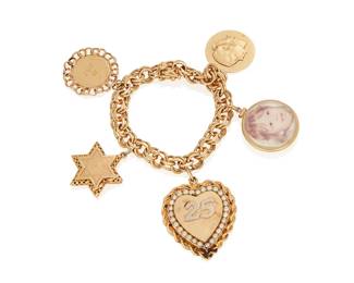 206
A Gold Charm Bracelet
The fancy link charm bracelet suspends four gold charms and one picture charm, in 14K gold.
57.14 grams (without picture charm)
7" L
Estimate: $1,500 - $2,000