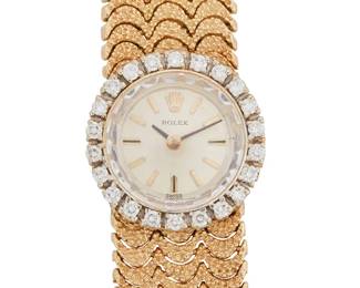 122
Lady's Gold And Diamond Wristwatch, Rolex
Ref: 12877
Dial: Silver tone with baton hands and markers
Movement: 17-jewel, calibre 1400
Case: 17 mm 14K gold round case with white gold bezel, set with round brilliant-cut diamonds estimated 0.20 carat total weight.
Bracelet/Clasp: 14K gold textured with hidden box clasp, 6 1/2" L
42.2 grams
Bracelet: 6.25" L
Estimate: $2,000 - $3,000
