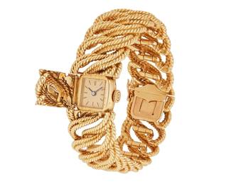 116
A Gold Covered Dial Bracelet Watch, French
Retro 18K gold covered dial, with French marks for 18K gold.
Dial: Gold tone with baton hands and numerals
Case: 13 x 15 mm, Cushion shape, concealed, back secured by two screws
Bracelet: 18K gold, interlocking twisted wire with hidden box clasp and safety catch, 6 3/4" L
107.5 grams
Estimate: $5,000 - $7,000