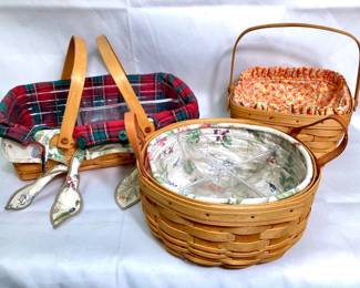 JOSW961 Longaberger Basket Trio 1 Rectangular swing handled gathering basket with removable plastic divided liner and 2 removable fabric liners, 1 round button basket with leather handle basket with removable quad plastic divider and 1 removable botanic print fabric liner, 1 square gathering basket with swing handles, 1 candy corn patterned fabric liner.