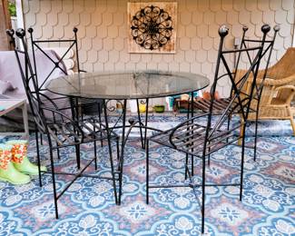 Black, heavy iron patio table with 4 chairs, Patio Chair and Coffee table, ratan chair, 2 outdoor rugs (1 new) and iron decor