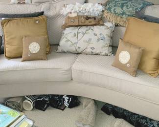 Beautiful curved sofa, decorative throw pillows, round wood side table