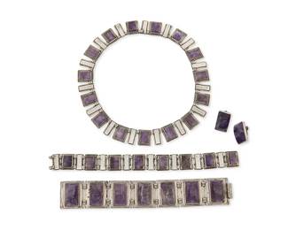 2121
A Group Of Fred Davis Mexican Silver And Amethyst Jewelry
Frederick W Davis (1880-1961)
Pre-1948; Mexico City, Mexico
Stamped: FD for Fred Davis; further variously stamped: Fred Davis / Sterling / Mexico / Silver / Made in Mexico
Four works comprising a necklace of alternating rectangular set cut amethyst and sterling silver panel links (15.5" L x 0.75" H) together with a matching sterling silver and amethyst link bracelet (8.375" L x 0.75" H), a wide rectangular silver and carved amethyst link bracelet (7.5" L x 1.125" H), and a pair of set amethyst screw back earrings (each: 0.875" H), 5 pieces
236.9 grams gross
Estimate: $1,200 - $1,800